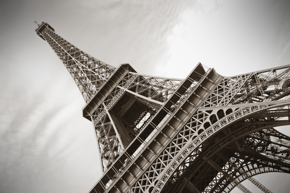 Sepia-toned view of the Eiffel Tower, shot from the ground.