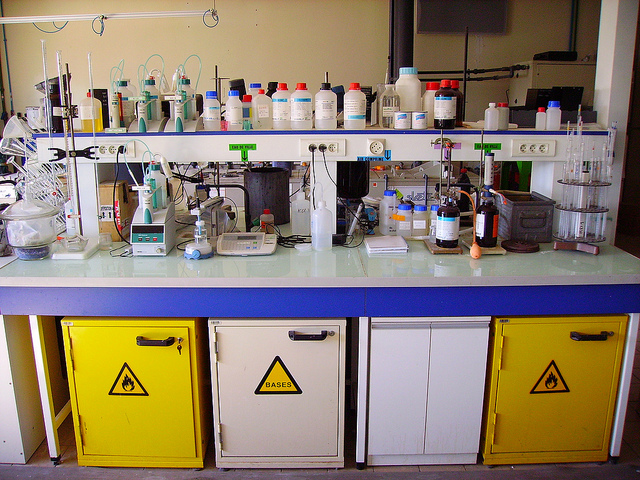 A chemistry lab bench covered with bottles, instruments, and other equipment.