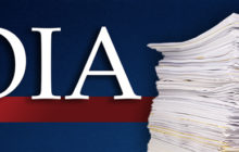 FOIA in large white letters on a red line on a blue background. On the right, a hand holds the top papers of a large stack.