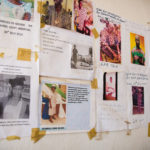 A wall covered in a variety of posters, some handwritten, some typed, stuck to the walls with pieces of yellow tape. Each has a photo of a person on, in nurses’ uniform, traditional clothing, or graduation gown. Many say RIP and include dates.