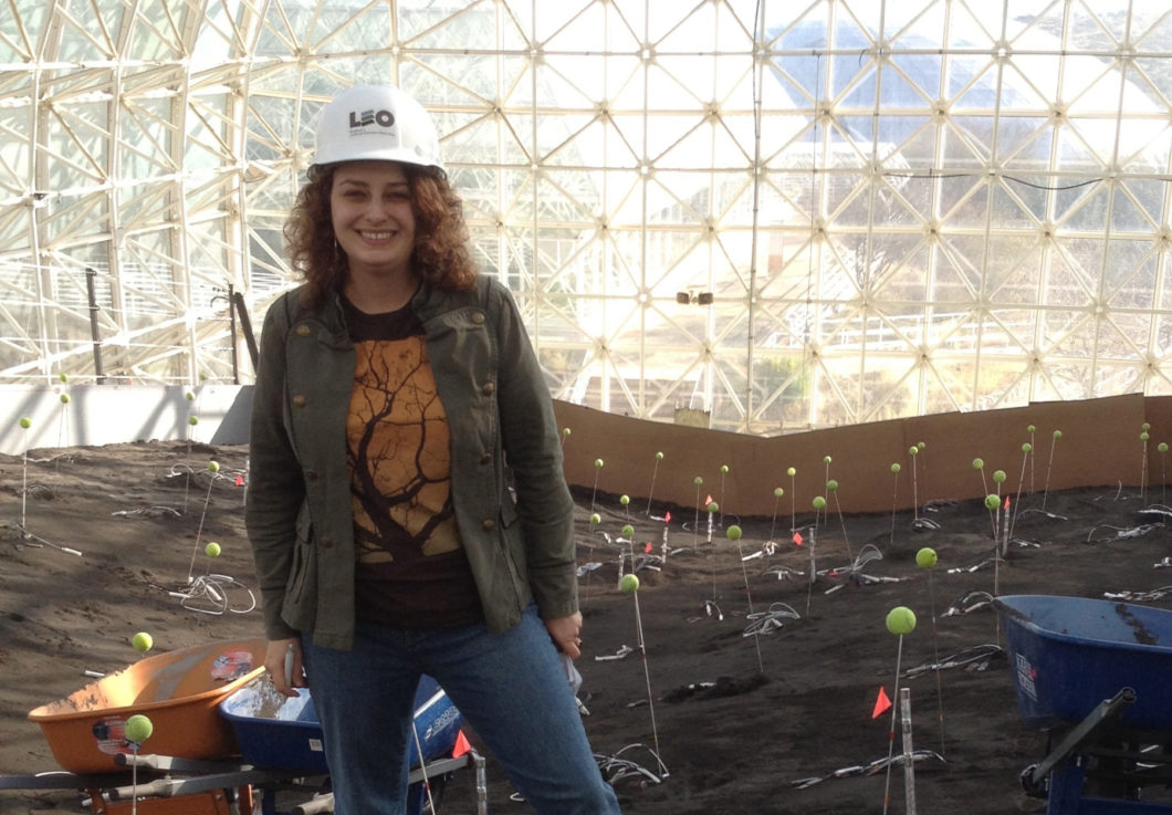 Photo of Alaina Levine standing in the Biosphere 2, a research facility of the University of Arizona.