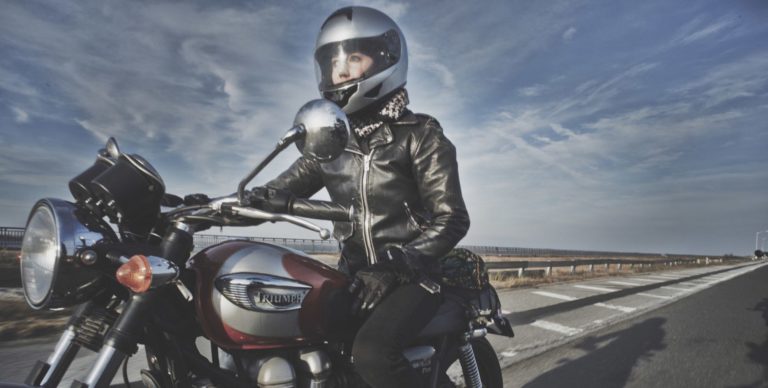Photo of Amy Maxmen on a motorcycle. There is a blue sky with some faint clouds in the background.