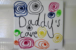 A child's drawing showing a few colored spirals and the words Daddy's cave.