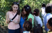 A photo of Jean Friedman-Rudovsky showing photographs on her camera to a group of kids living near sugar cane fields outside of Santa Cruz, Bolivia.