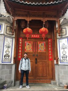 Joshua Sokol in front of a traditional door of a building in China.