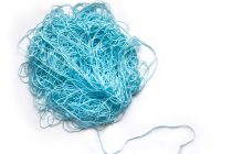 A tangle of blue yarn on a white background, with a single, orderly thread emerging from the lower right of the tangled ball.