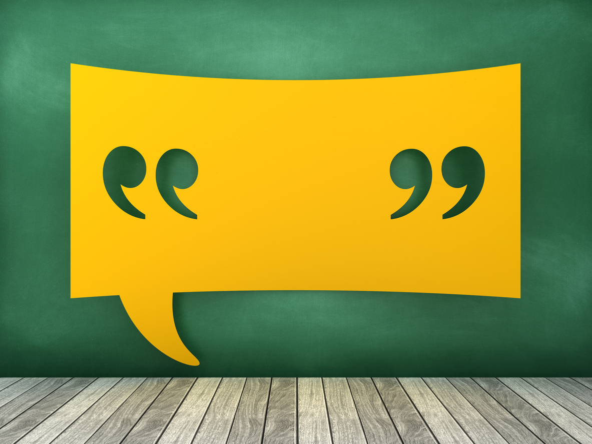 A rectangular yellow speech bubble containing a set of quotation marks, on a green background.